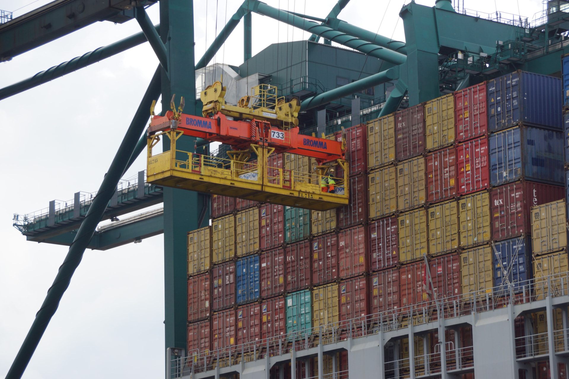 Container ship being loaded at port by a ship-to-shore crane