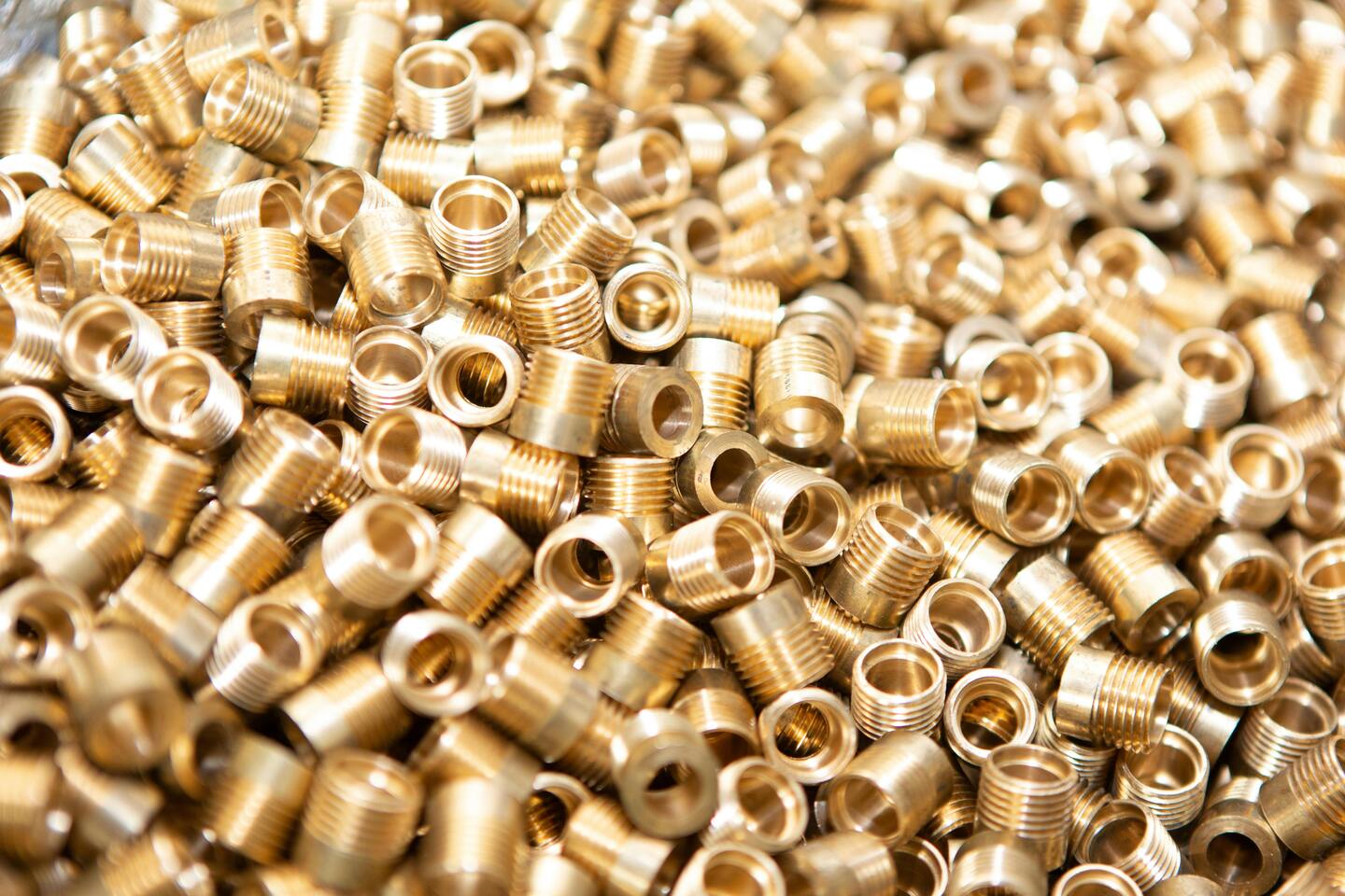 Close-up of machined brass turned components in bulk, representing automotive precision parts sourcing