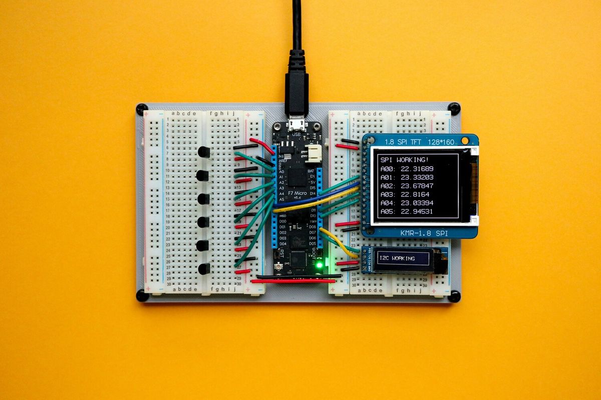 Microcontroller on breadboard with colored wires and small display screens